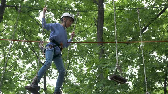 Child climbing in rope park. alt
