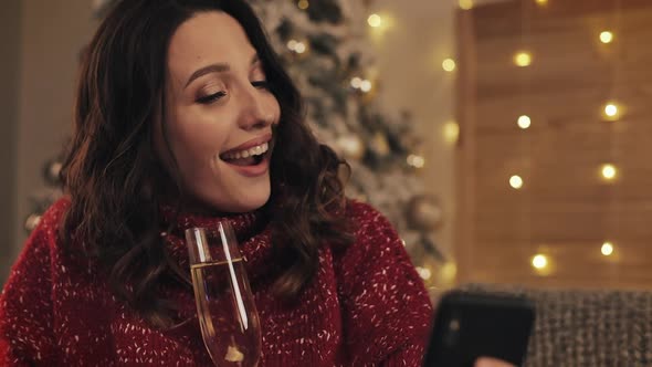 Close Up Amazed Young Beautiful Woman Holding Glass Champagne Using Her Mobile Phone Smile Sitting alt