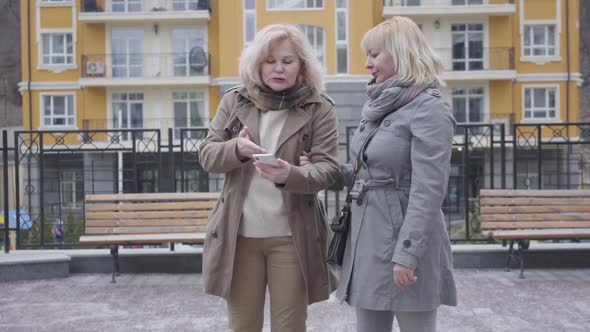 Portrait of Senior Caucasian Women Discussing the Route Emotionally and Leaving To Opposite alt