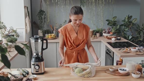 Vegetarian Woman Unpacking Groceries in Kitchen alt