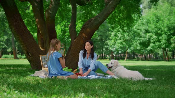 Happy Mother Resting with Daughter on Picnic alt