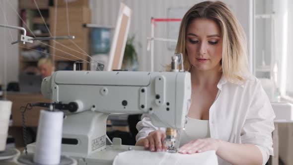 Young Beautiful Seamstress in the Workplace Smiling and Looking at Camera