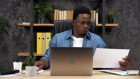 Thoughtful African American Businessman Looks Business Report in Office alt