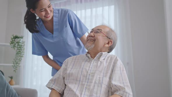 Asian nurse take care of happy senior man on wheelchair