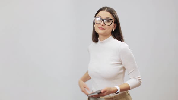 Woman In Beige Outfit Spraying A Sanitizer And Wiping Her Cell Phone