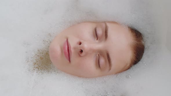 Face of Young Woman Submerged into Bath Water alt