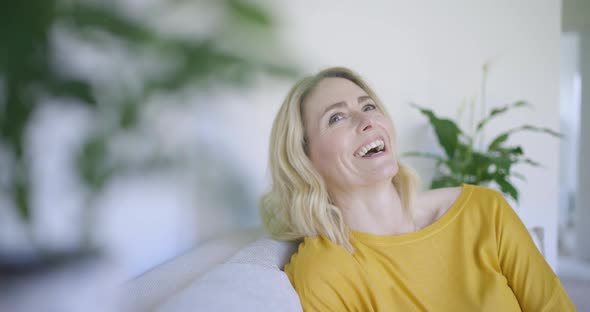 Cofident woman sitting on couch, laughing