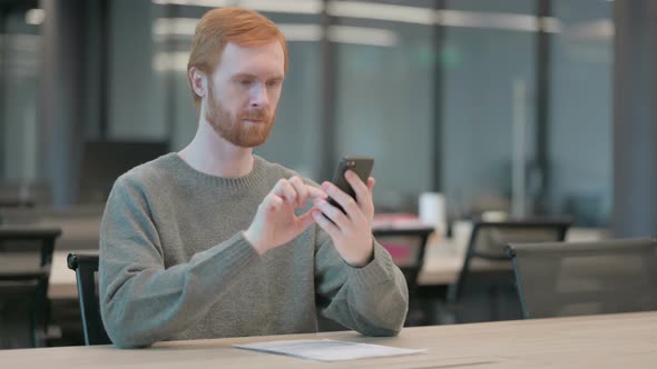 Attractive Young Man Using Smartphone in Office alt