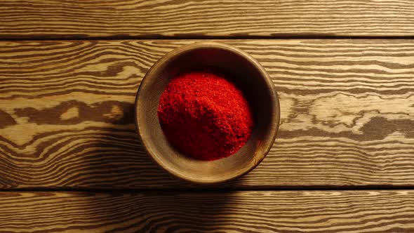 Portions Of Ground Red Pepper Appear In A Wooden Cup