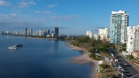 Aerial view of a beach side town with a city skyline in the distance alt