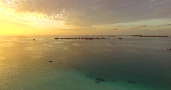 Aerial drone view of a scenic tropical island in the Maldives at sunset. alt