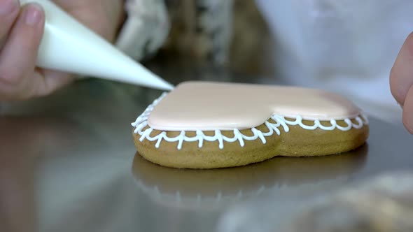 Baker Decorating Heartshaped Cookie alt