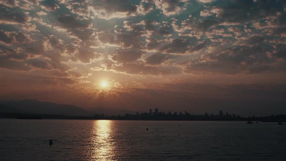 Wide static shot of Sunrise over Vancouver Skyline with beautiful clouds alt