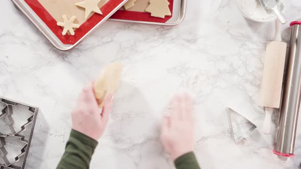 Flat lay. Step by step. Cutting out shapes with Christmas cookies cutter from sugar cookie dough. alt