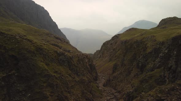 Close Proximity Valley Drone Flight through Cliffs in England in Overcast Weather alt