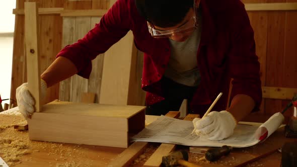 Woodwork and furniture making concept. Stylish craftsman working in his carpentry workshop alt