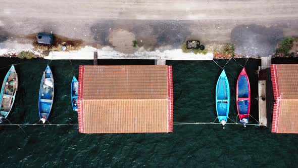 Top view of fishing huts with moored boats. alt
