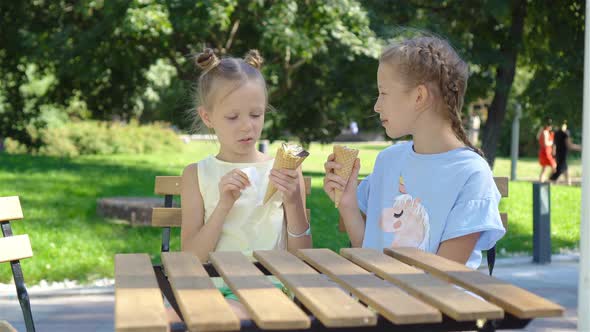 Little Girls Eating Ice-cream Outdoors at Summer in Outdoor Cafe