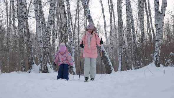 Little Girl Learning To Ski with Mom in a Park alt