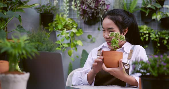 woman sell plant online laptop alt