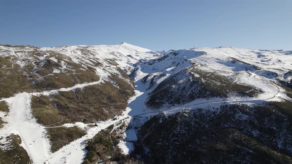 White snowy slopes down Sierra Nevada ski resort in Spain; aerial view