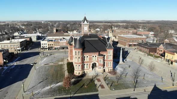 Aerial drone video orbiting around a red brick historic building in the town square alt