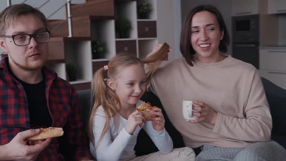 Smiling Woman, Little Daughter and Man Eating Pizza and Cuddle