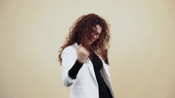 The Young Woman with Curly Hair Dances with Her Hands Holds Her Fingers in Her Fists Shakes Her alt