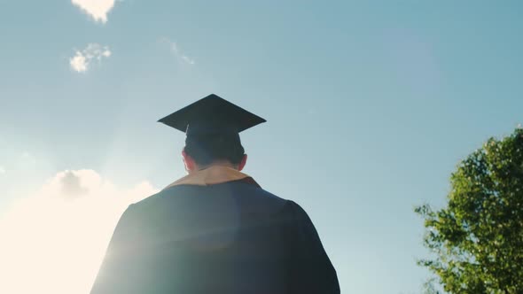 Rear View of the University Graduates Student at Silhouette Sunset Goes on the Road alt