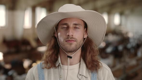 Caucasian Man with Red Hair Standing at Farm with Goats alt