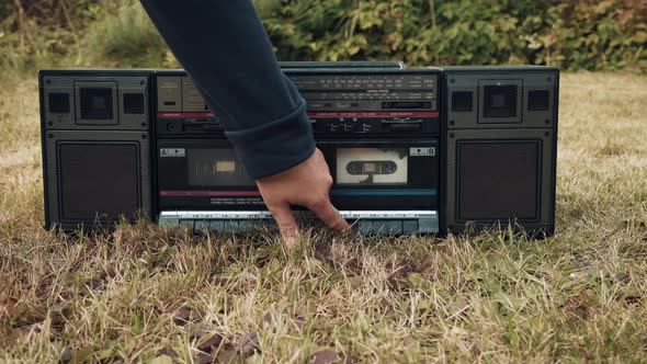 Woman Presses Play Button on Old Retro Tape Recorder and Picks It Up By Handle