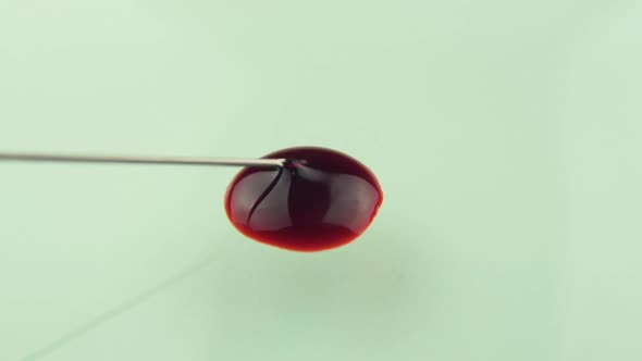 Drop Of Blood From Sterile Hypodermic Needle Poured Onto Glass Surface Slowly Spreading