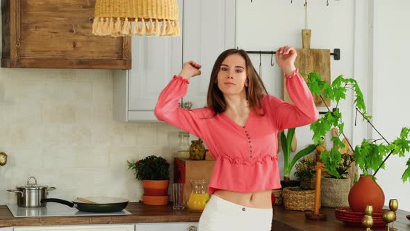 Young Housewife Dancing While Preparing Food In The Kitchen