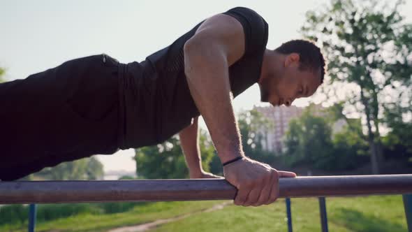 Muscular African Athlete Performs on Gym Equipments Outdoors alt