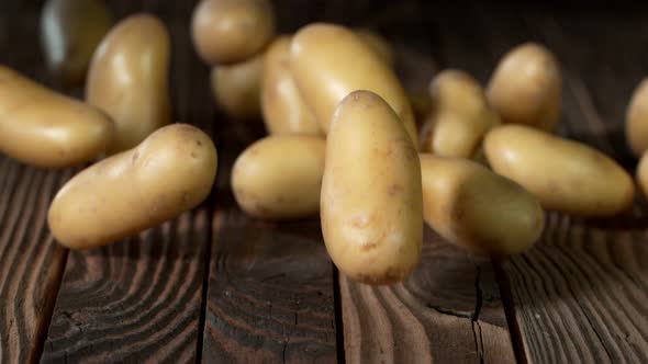 Super Slow Motion Shot of Potatoes Rolling on Old Wooden Table at 1000Fps alt