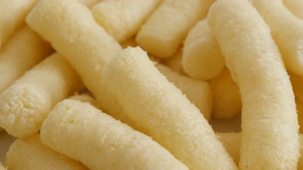 Puffcorn tasty snack pile in the bowl close-up 4K 2160p 30fps UltraHD tilting footage - Corn flips p alt