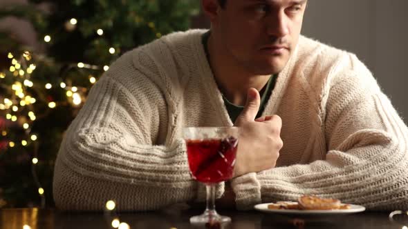 sad man sitting at the holiday table at Christmas