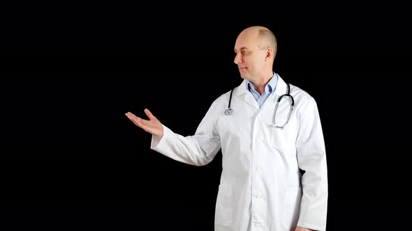 Bald Doctor in Medical Gown Showing Hand To Somewhere While Presentation on Black Background alt