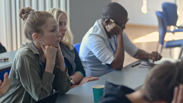 Young Multiethnic Students are Having Study Time at Table in University Room Irrl alt