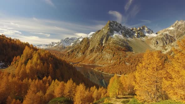 Side POV Walking on Fall Path with Woods Trees Lake and Snowy Mounts alt