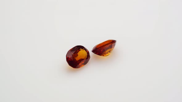 Natural Red Hessonite Garnet Gemstone on the White Background on the Turning Table