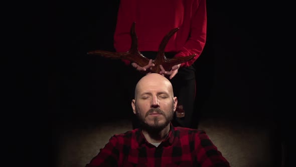 Adultery Woman Cheated on Her Man Wearing the Horns of a Cuckold Sets Moose Deer Horns on His Head alt