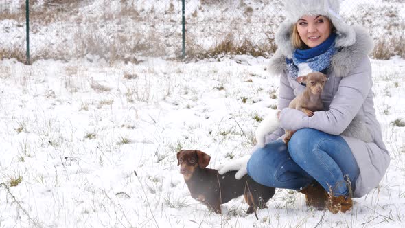 Woman Playing with Dogs in Winter