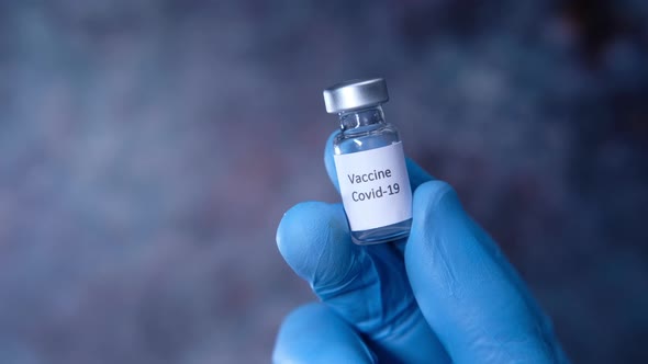 Doctor Hand in Protective Glove Holding Coronavirus Vaccine, Close Up alt
