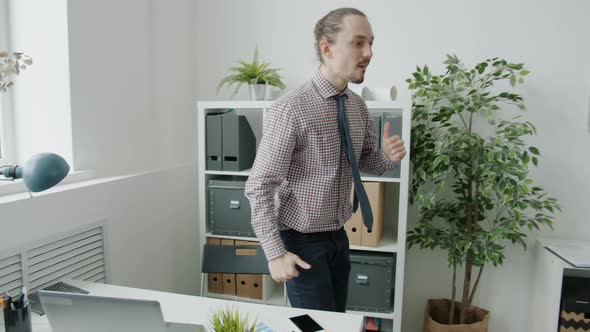 Portrait of Excited Guy Employee Dancing and Doing Highfive Sharing Good News with Team in Workplace alt