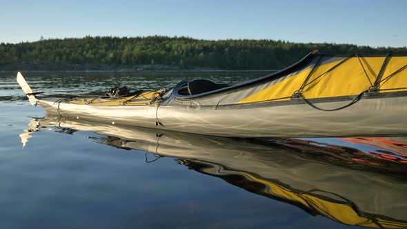 Yellow Sports Kayak on Water Near Bank of Tranquil Lake alt