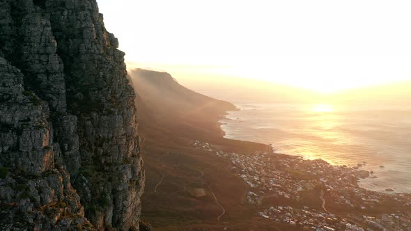 Aerial Shot Ascending Up the Side of a Mountain with a Sunset Over the Ocean