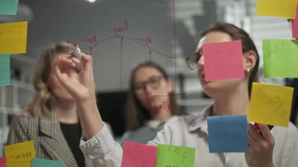 Creative Business Team Brainstorming Ideas Working Together Near Glass Wall With Sticky Notes alt