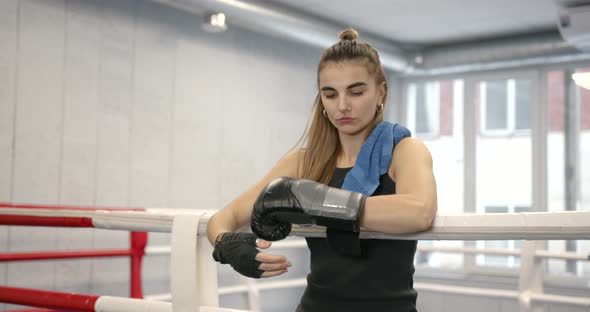 Young Woman Putting on Boxing Gloves at Gym alt