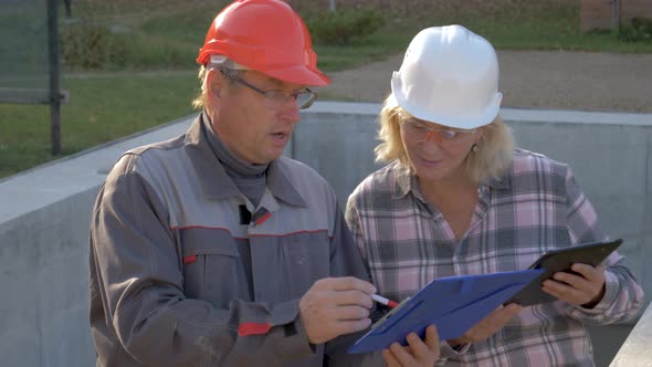 Builder And Client In Helmet Discuss Construction According To Plan Project alt